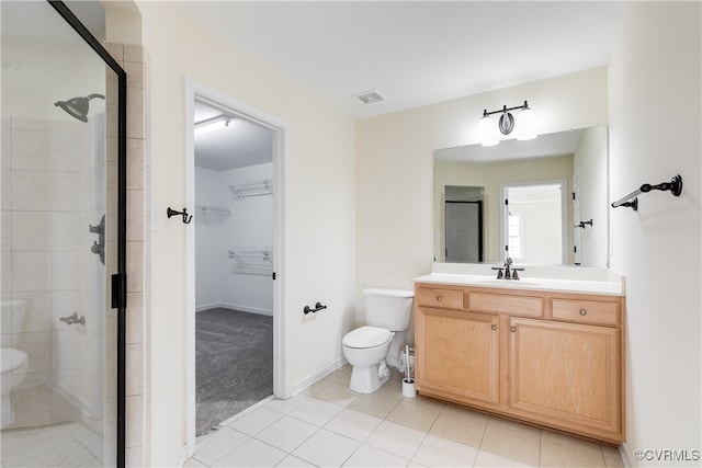 bathroom with tile patterned flooring, vanity, toilet, and an enclosed shower