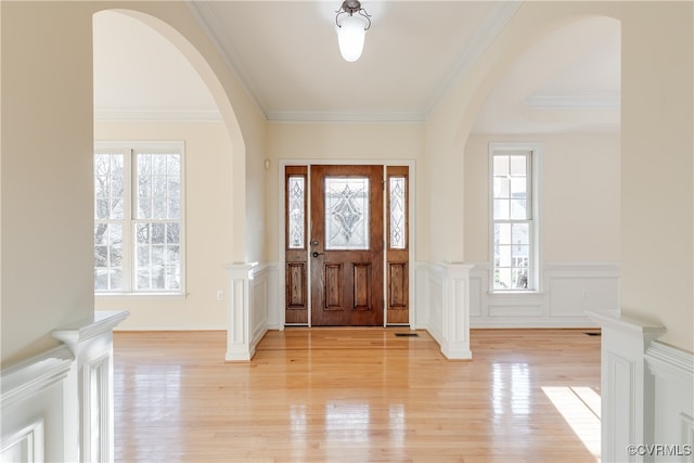 entryway with light hardwood / wood-style floors and ornamental molding