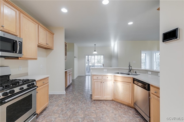 kitchen with plenty of natural light, hanging light fixtures, sink, and appliances with stainless steel finishes