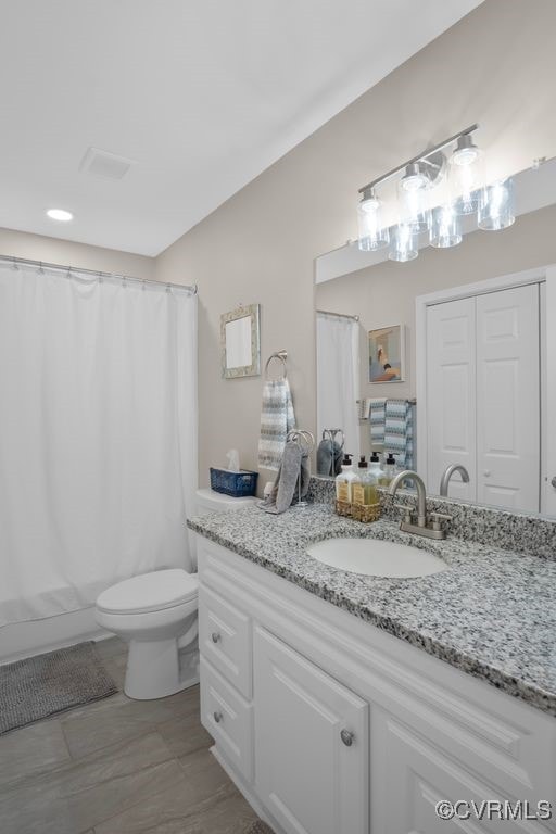 bathroom featuring vanity, toilet, and curtained shower