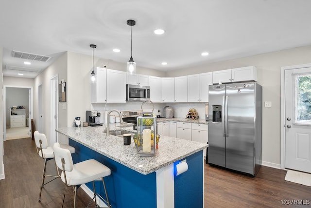 kitchen featuring kitchen peninsula, appliances with stainless steel finishes, white cabinetry, dark hardwood / wood-style floors, and sink