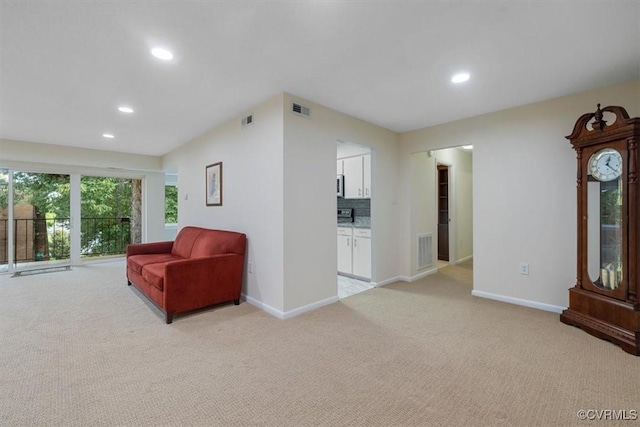 sitting room with baseboards, light carpet, recessed lighting, and visible vents