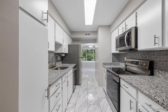 kitchen featuring visible vents, marble finish floor, baseboards, a sink, and appliances with stainless steel finishes