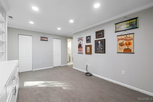 interior space featuring ornamental molding and dark colored carpet