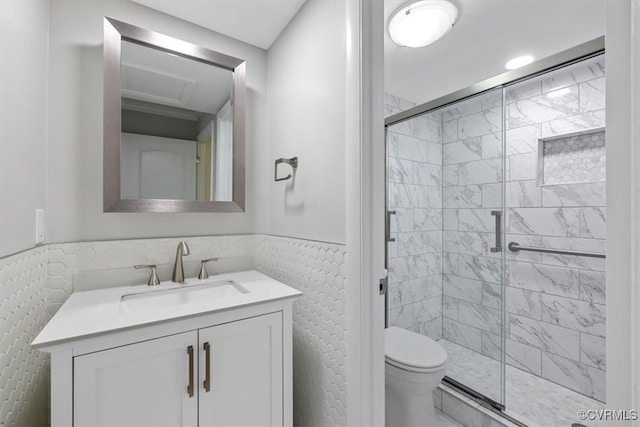 bathroom featuring vanity, tile walls, a shower with shower door, and toilet