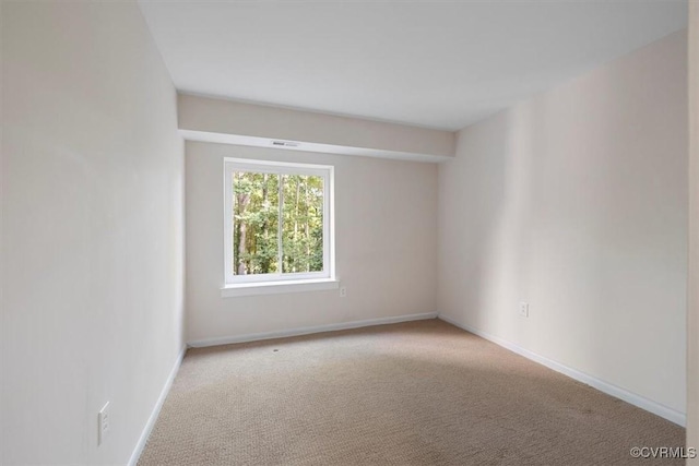 carpeted spare room with baseboards and visible vents
