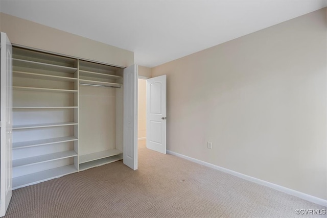 unfurnished bedroom with light carpet and a closet