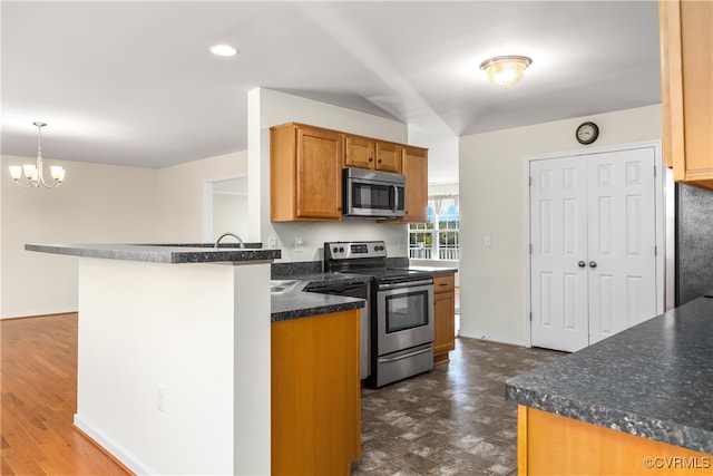 kitchen with dark hardwood / wood-style floors, kitchen peninsula, decorative light fixtures, an inviting chandelier, and appliances with stainless steel finishes