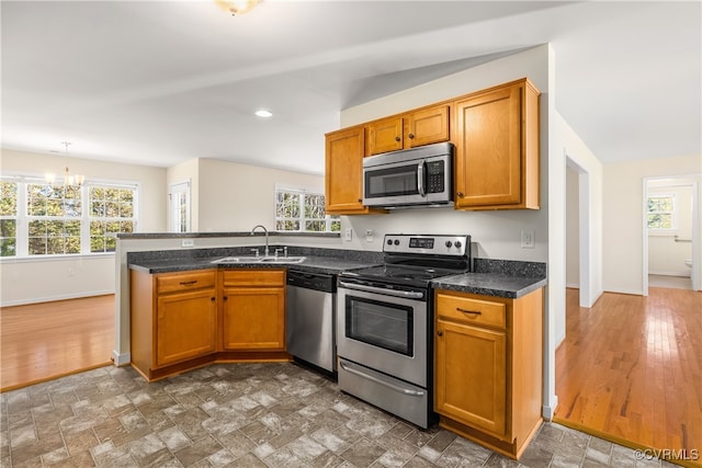 kitchen with kitchen peninsula, stainless steel appliances, plenty of natural light, and dark hardwood / wood-style flooring