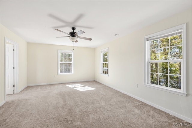 carpeted spare room featuring ceiling fan