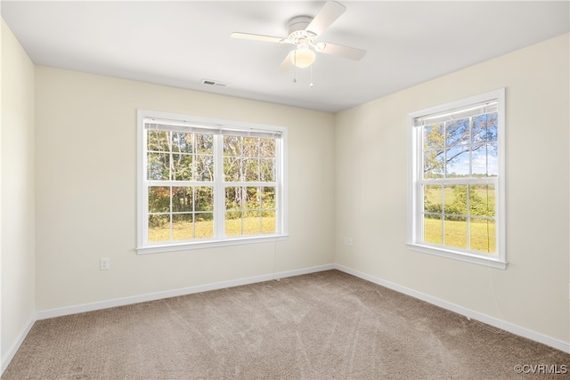 carpeted spare room with ceiling fan