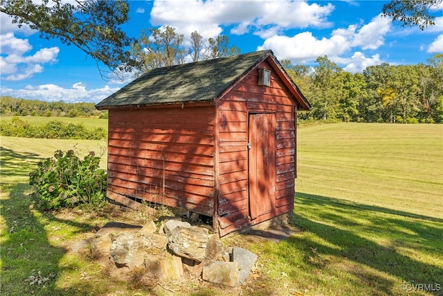 view of outdoor structure with a lawn and a rural view