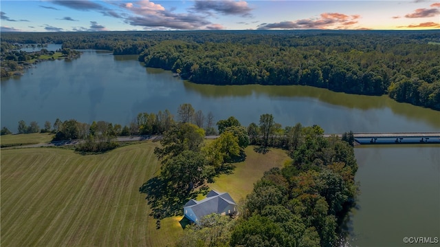 aerial view at dusk featuring a water view