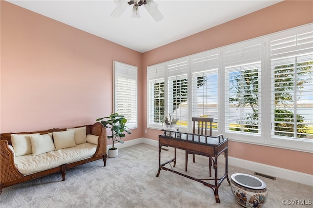 carpeted office space with a healthy amount of sunlight and ceiling fan