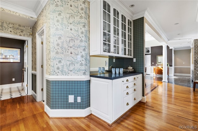 kitchen with white cabinetry, ornate columns, and ornamental molding