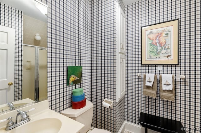 bathroom with sink, toilet, and an enclosed shower