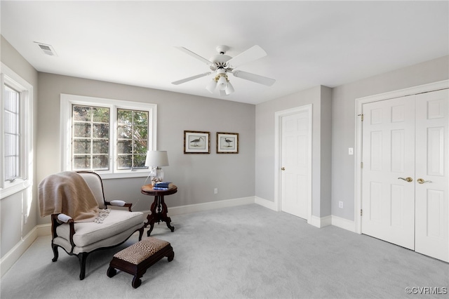 sitting room featuring light carpet and ceiling fan