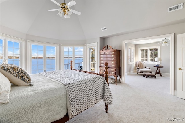 bedroom featuring carpet flooring, access to exterior, ceiling fan, a water view, and high vaulted ceiling