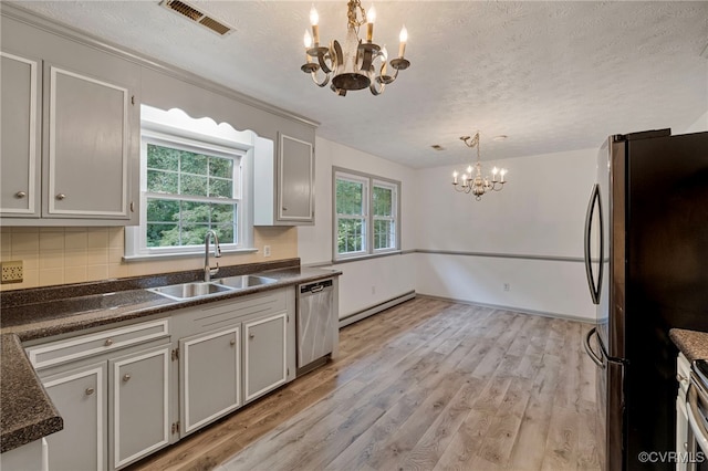 kitchen with a wealth of natural light, sink, appliances with stainless steel finishes, and hanging light fixtures