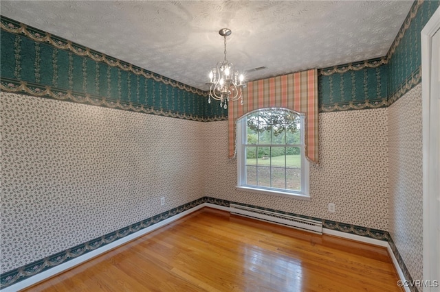 unfurnished dining area featuring hardwood / wood-style flooring, a textured ceiling, and an inviting chandelier