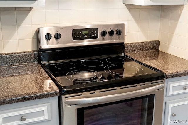 kitchen with stainless steel electric range and tasteful backsplash