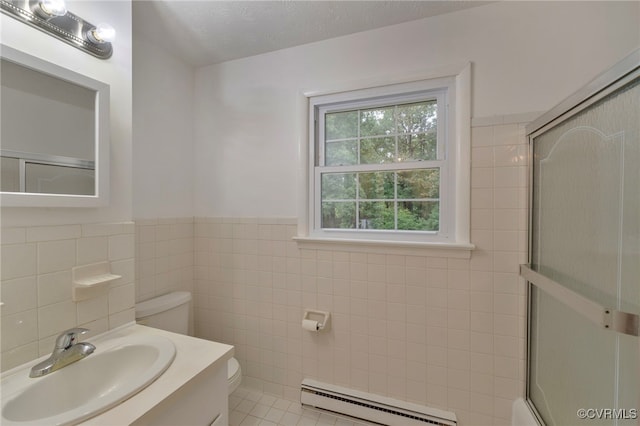 bathroom featuring a baseboard heating unit, toilet, walk in shower, tile walls, and vanity