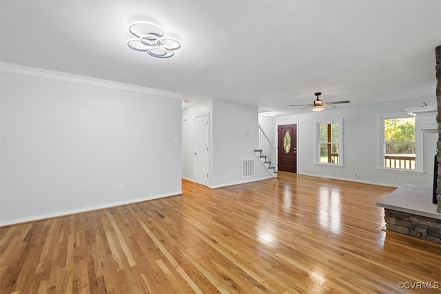 unfurnished living room featuring light hardwood / wood-style flooring, ornamental molding, a fireplace, and ceiling fan