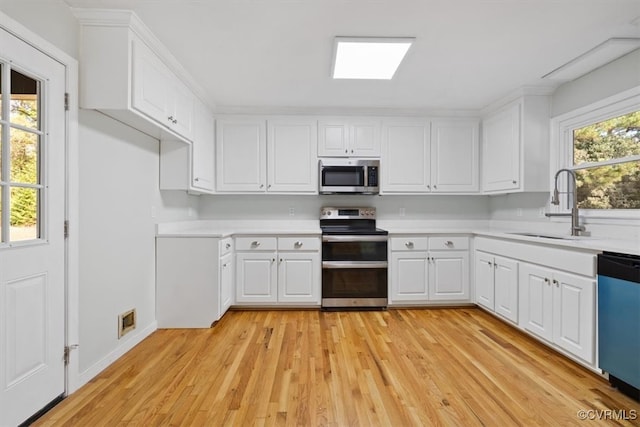 kitchen featuring light hardwood / wood-style flooring, white cabinets, stainless steel appliances, and sink