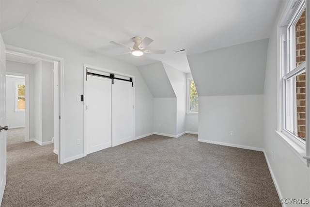 bonus room featuring carpet floors, plenty of natural light, and a barn door