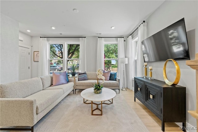 living room featuring light wood finished floors, visible vents, and recessed lighting