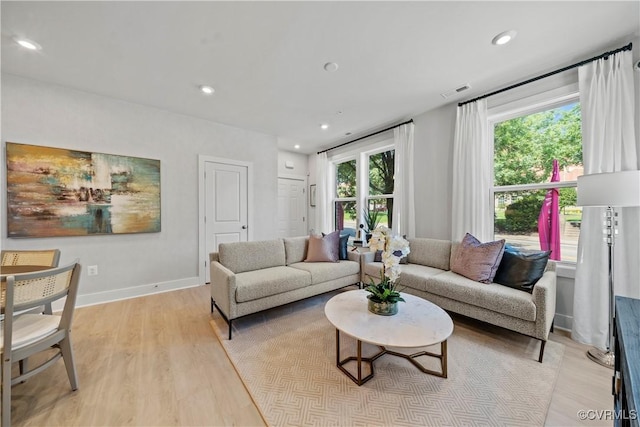 living room featuring light wood-style floors, recessed lighting, visible vents, and baseboards