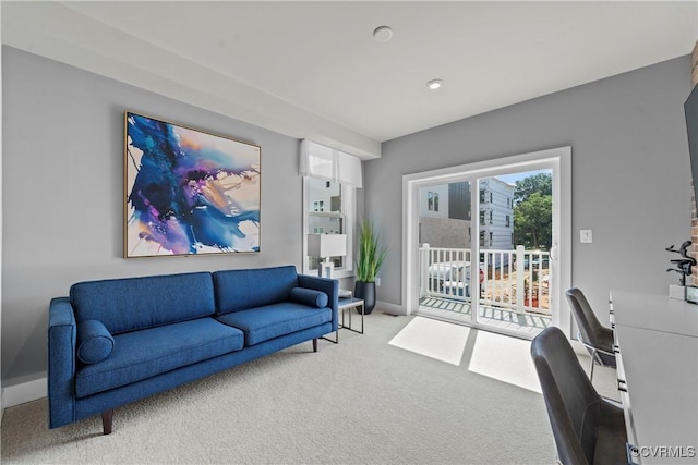 carpeted living area featuring baseboards