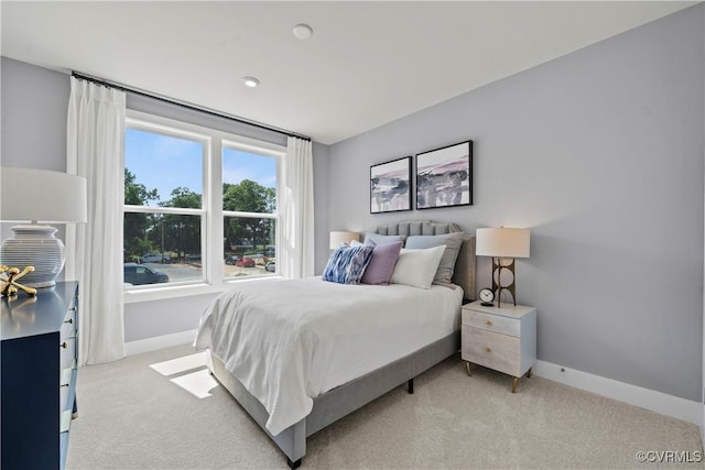 bedroom featuring light carpet and baseboards