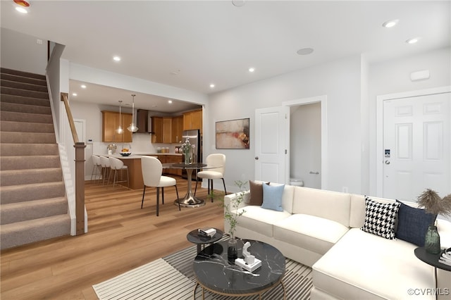 living area featuring light wood-style flooring, stairs, and recessed lighting