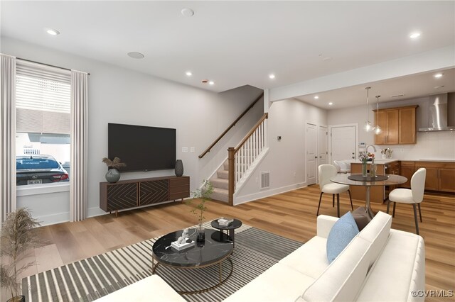 living area featuring recessed lighting, visible vents, baseboards, stairs, and light wood finished floors