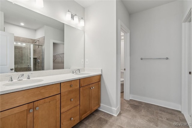 full bathroom with toilet, a stall shower, double vanity, and a sink