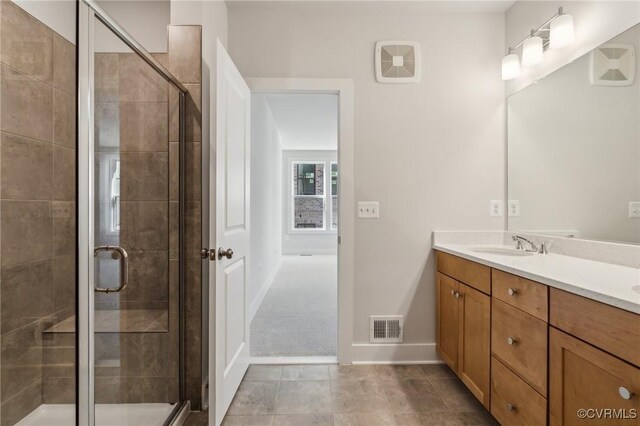 full bath featuring a stall shower, a sink, and visible vents