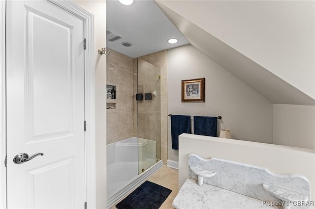 bathroom with vaulted ceiling, tile patterned floors, and a shower with shower door