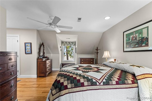 bedroom featuring light hardwood / wood-style floors, vaulted ceiling, and ceiling fan