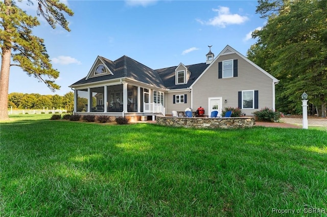 back of property with a sunroom and a yard