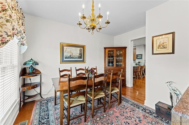 dining room featuring hardwood / wood-style flooring and a chandelier