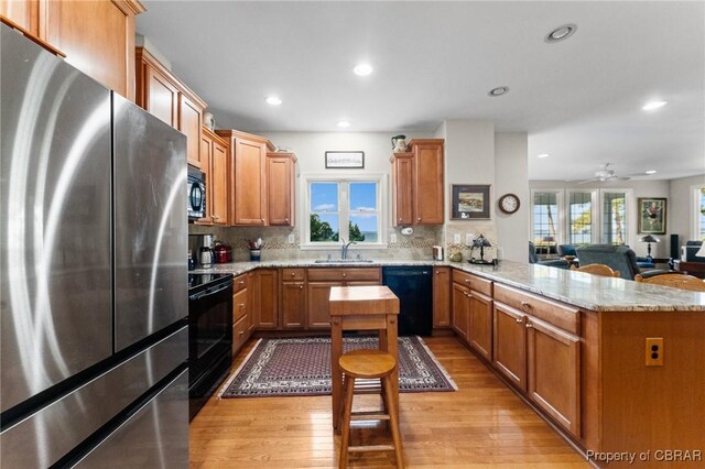 330 River Village Dr, Weems, VA 22576 - kitchen with black appliances, a peninsula, light wood-type flooring, decorative backsplash, and recessed lighting