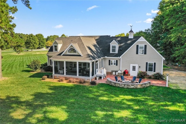 rear view of house with a yard, a patio, and a sunroom