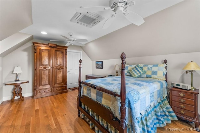 bedroom with ceiling fan, vaulted ceiling, and light wood-type flooring