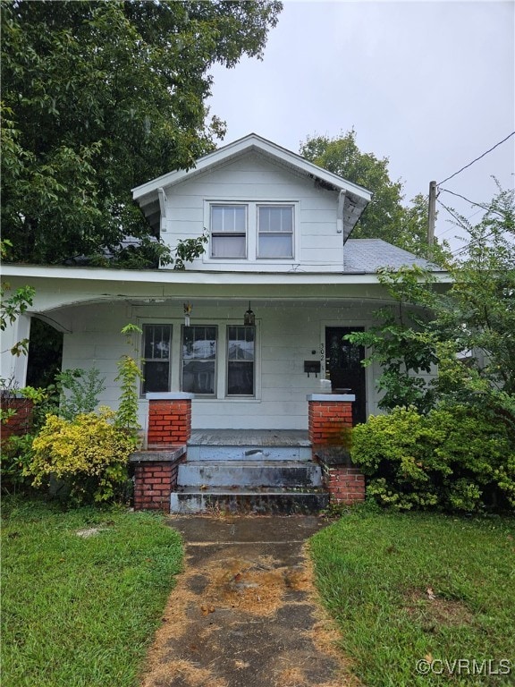 view of front of house with a porch and a front lawn