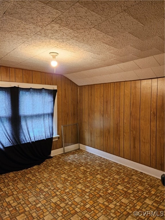 spare room featuring wooden walls