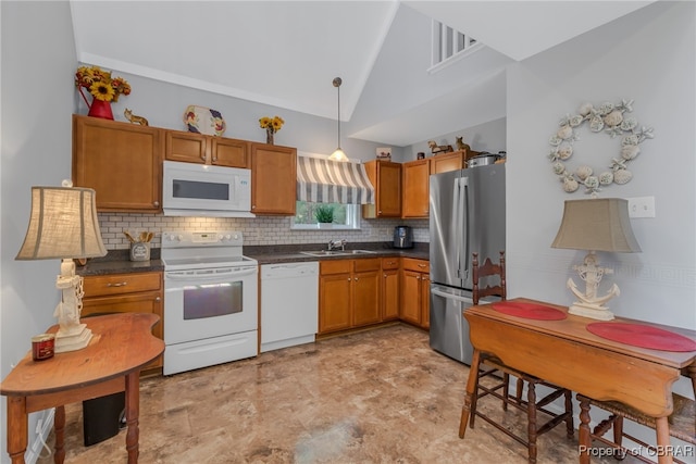 kitchen with white appliances, tasteful backsplash, sink, hanging light fixtures, and high vaulted ceiling