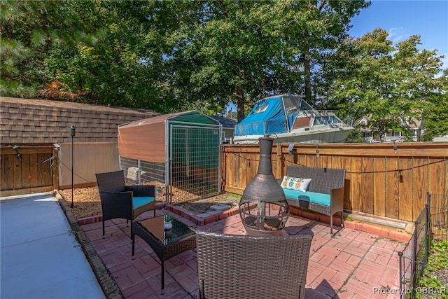 view of patio featuring a shed and a fire pit