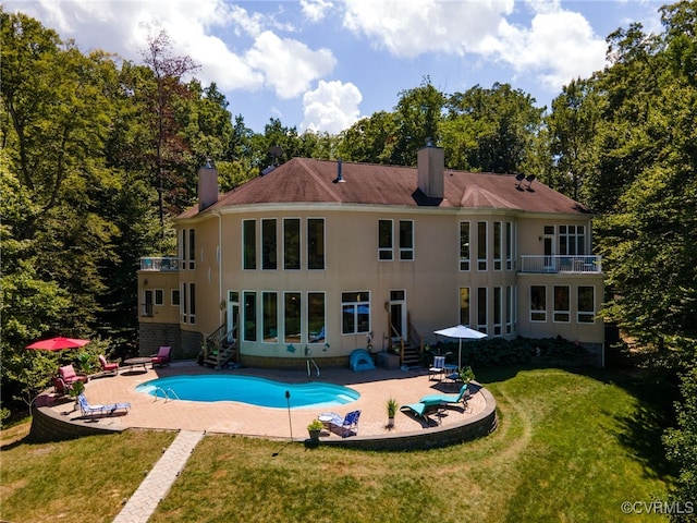 back of property with a patio, a yard, and a balcony