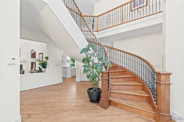 staircase featuring a high ceiling and hardwood / wood-style flooring